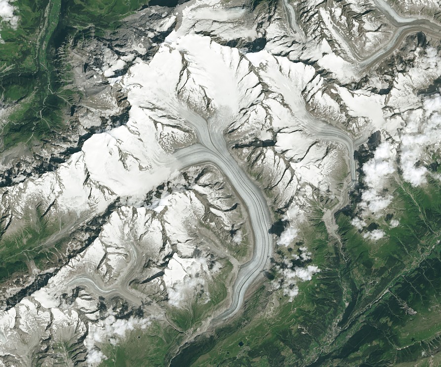 Le glacier d’Aletsch et ses moraines sombres au milieu des sommets enneigés des Alpes suisses.