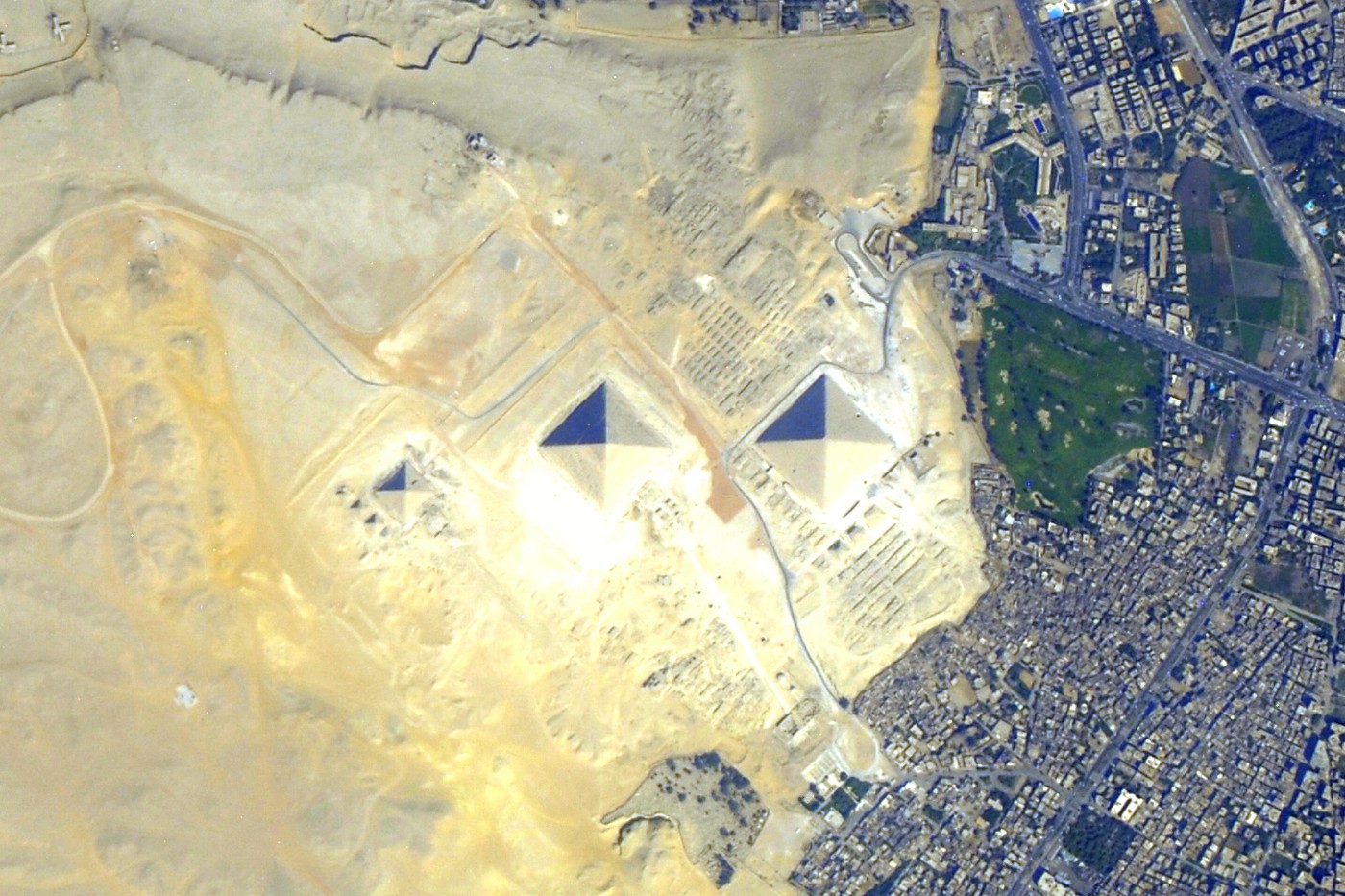 Les trois grandes pyramides de Gizeh vues depuis l’espace, à la limite du désert et de l’agglomération du Caire.