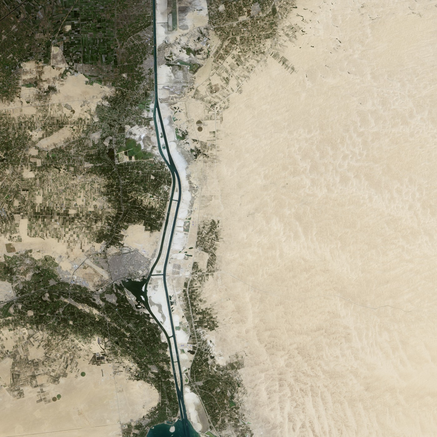 Les deux chenaux du canal de Suez au nord d’Ismaïlia, entre les terres cultivées et le désert égyptien.